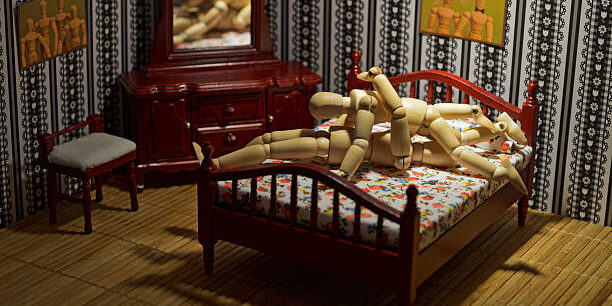 Wooden figures couple sixty-nine style in the bed.