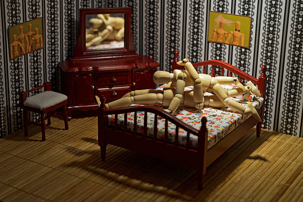 Wooden figures couple sixty-nine style in the bed.