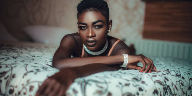 Beautiful young black woman lying on bed in bedroom. The perfect surprise