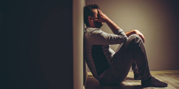 Young depressed man sitting on floor. Premature ejaculation