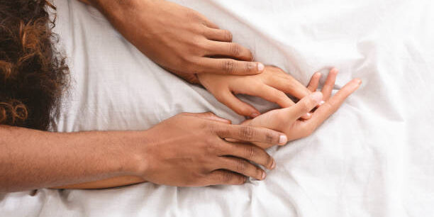 Black man and woman enjoying sexual foreplay in bed, free space
