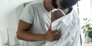 african american boyfriend kissing girlfriend neck at kitchen